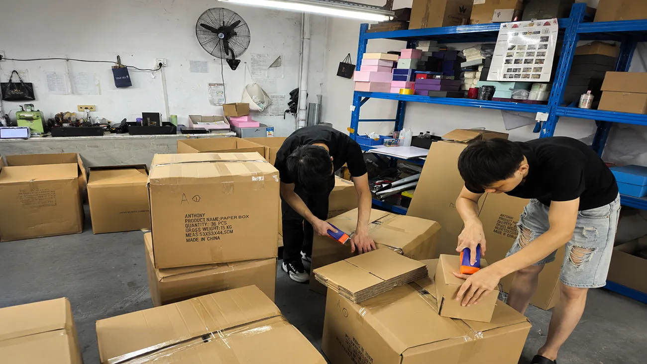 Workers inspect finished custom paper boxes in Crown Win Box Manufacturer China packaging printing factory warehouse, stable production capacity for on-time packaging delivery