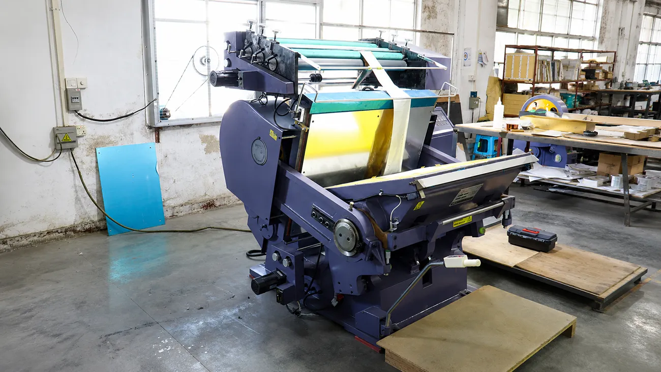 Crown Win Box Manufacturer hot stamping machine in packaging production workshop, professional foil stamping equipment for custom paper boxes